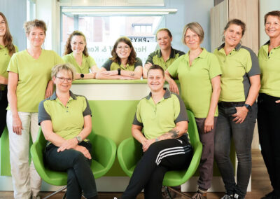 Praxisteam an Rezeption mit grüner Theke